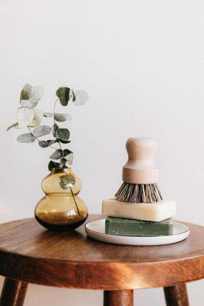 Natural soap on a wooden table and vase with plant